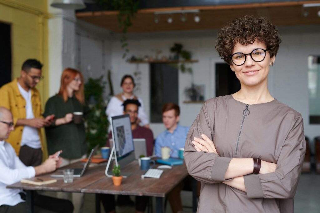 Mujer joven al frente de un equipo, representando el nuevo liderazgo millenial