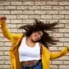 Mujer bailando feliz con ojos cerrandos, simboliza la libertad